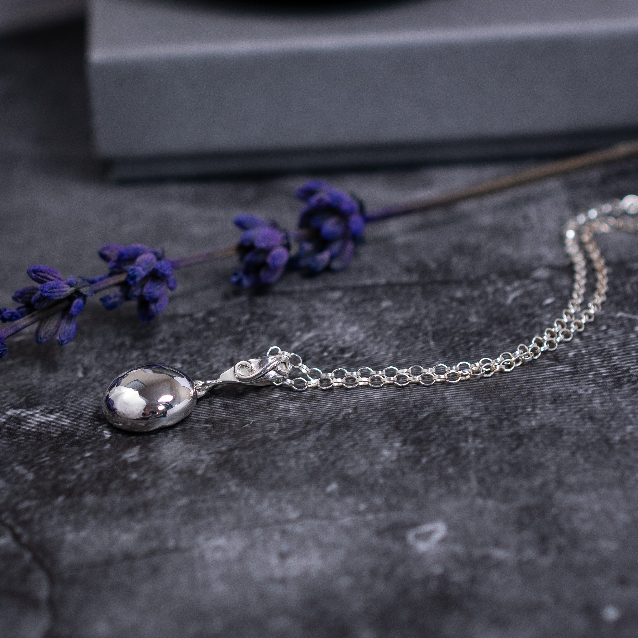 Sterling silver pebble pendant with a handmade swirl bail and an sdjustable belcher chain. 