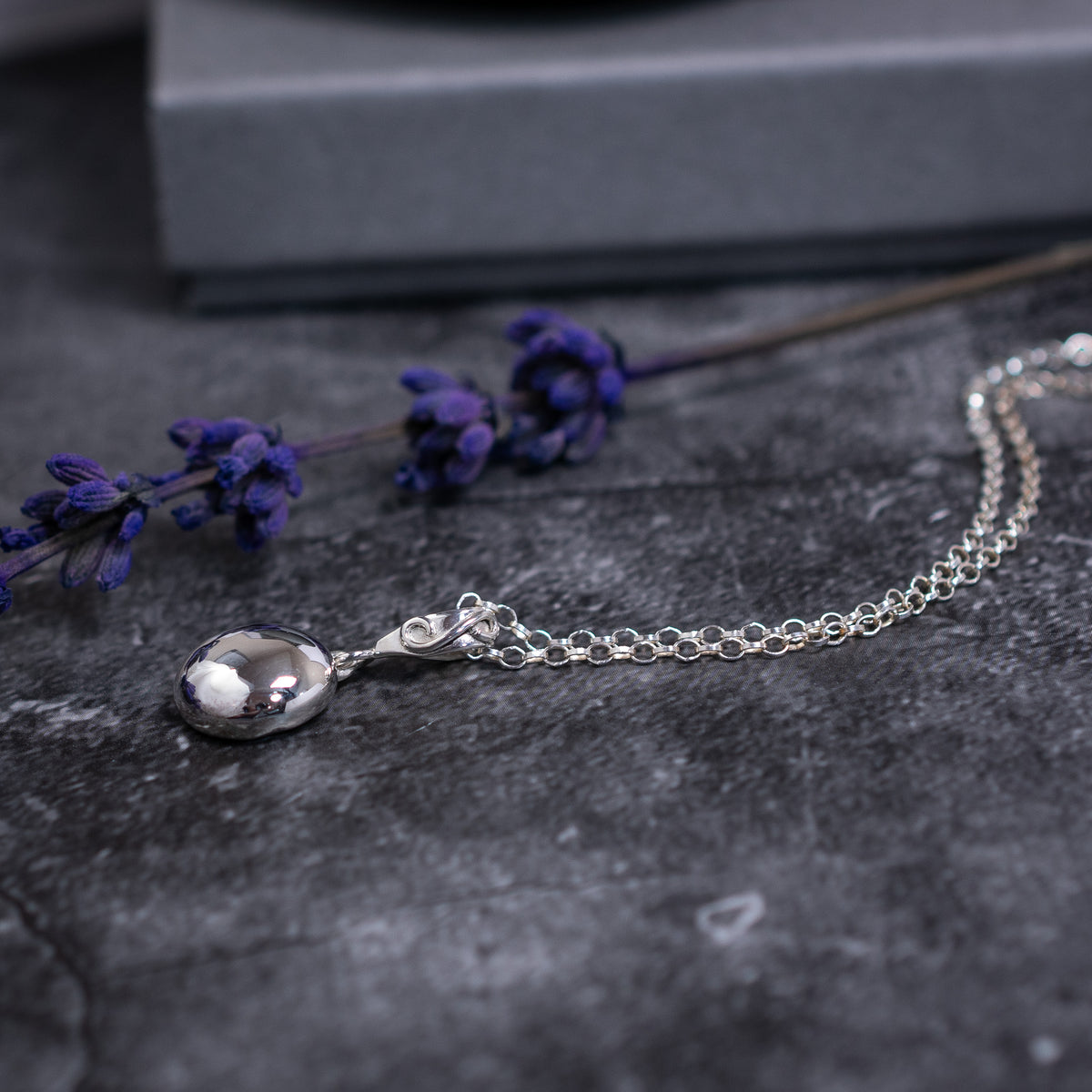 Sterling silver pebble pendant with a handmade swirl bail and an sdjustable belcher chain. 