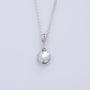 Silver necklace with a round Argentium smooth pebble pendant on a light gray background