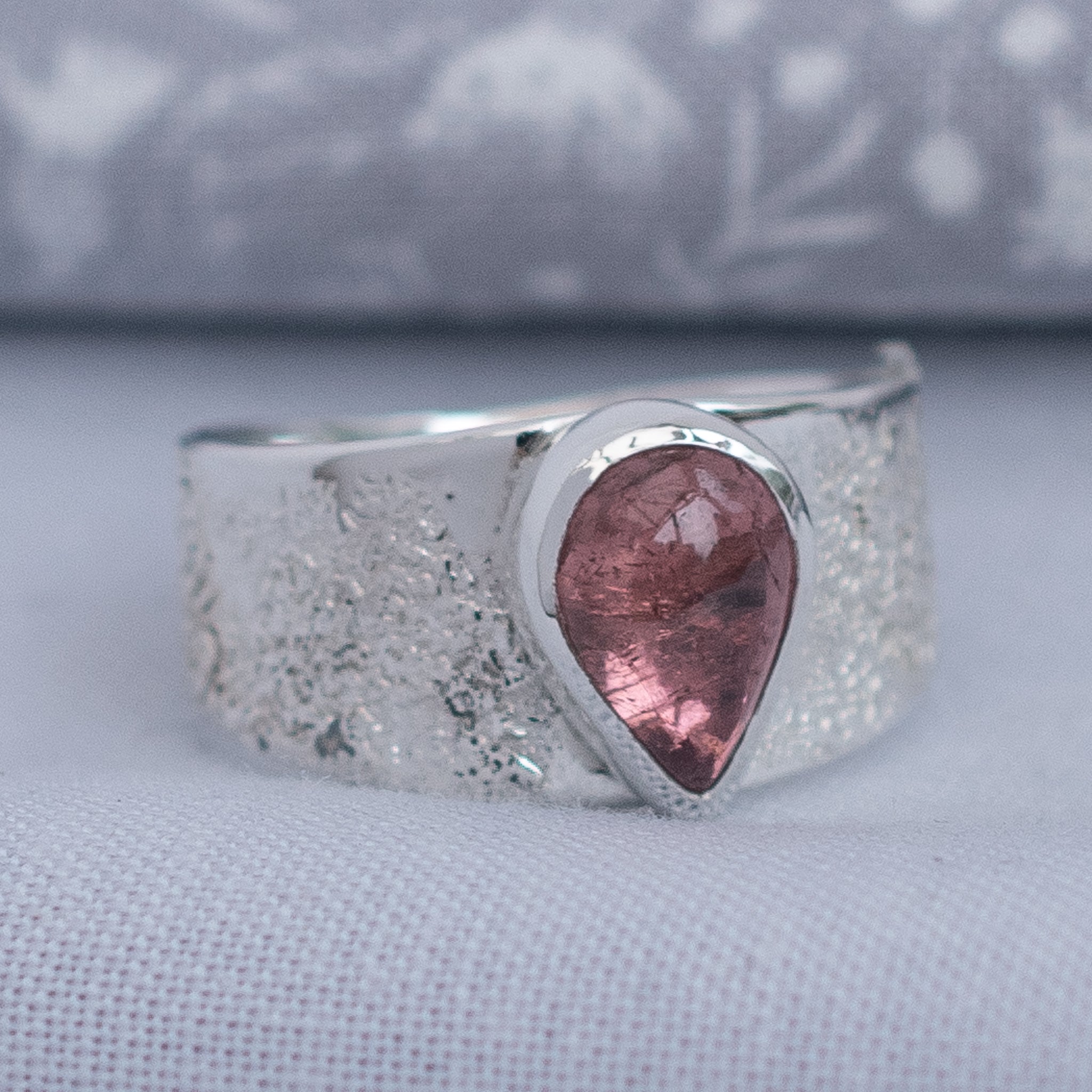 Side view of pink tourmaline ring with wide Argentium silver band
