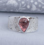 Natural pink pear-shaped tourmaline wide band ring in textured Argentium silver