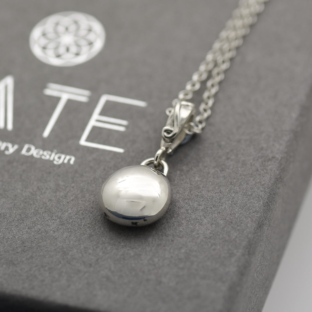 Smooth Silver pebble pendant with a detailed handmade swirl bail on a sterling silver chain. 