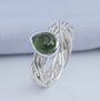 Close-up of natural olive green tourmaline in a polished silver setting