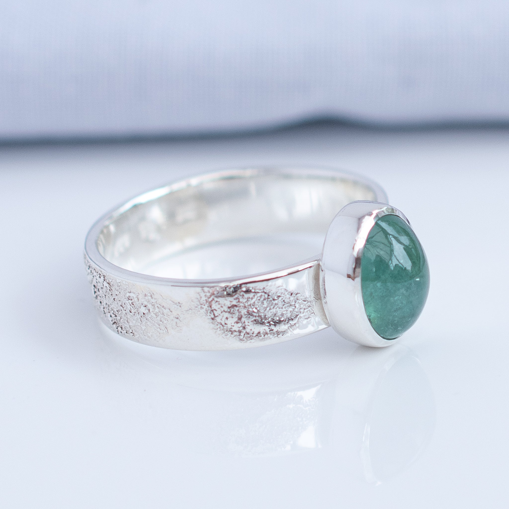 Sideview of natural mint green tourmaline set in textured Argentium silver