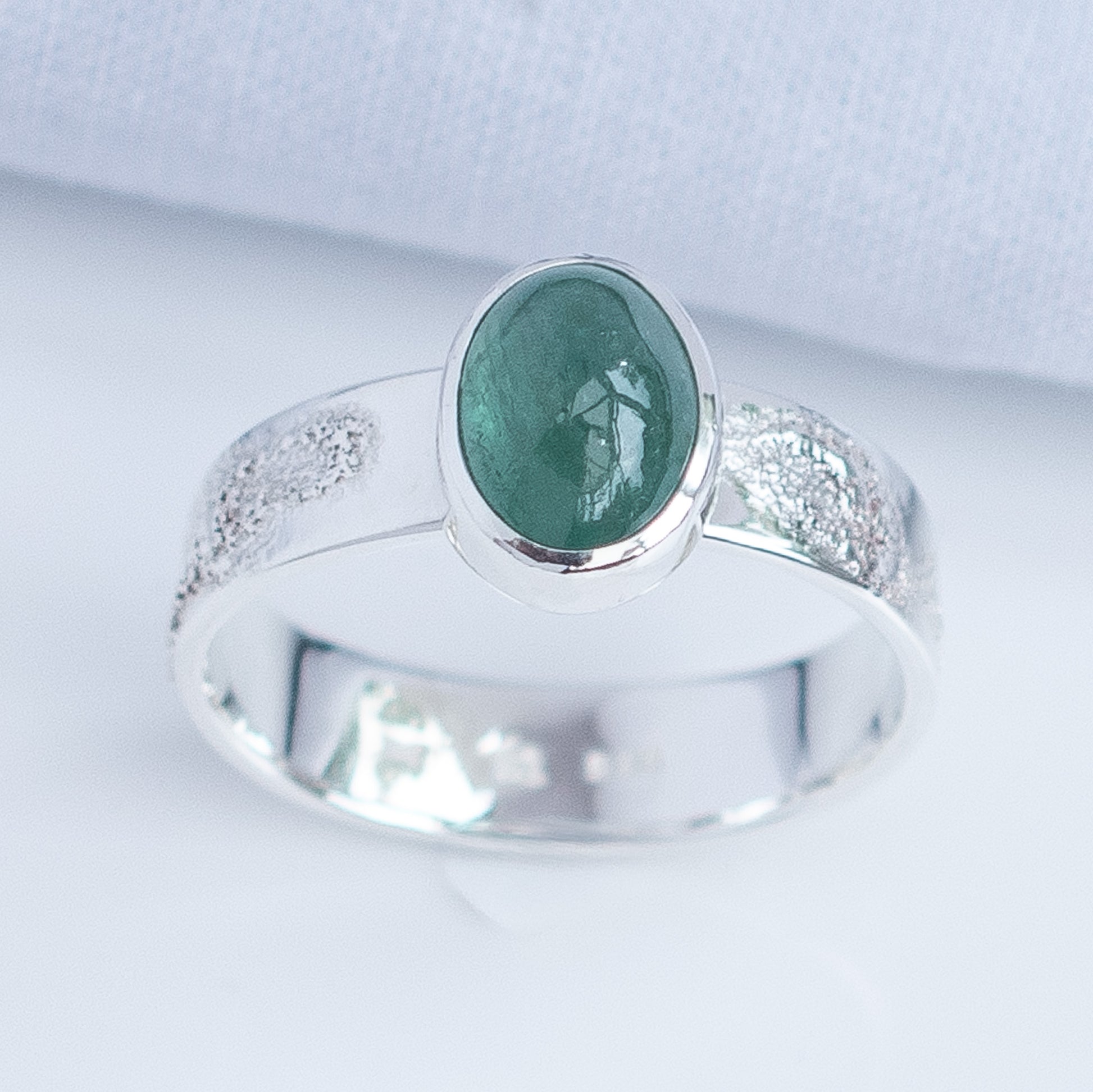 Close-up of mint green tourmaline gemstone in handmade silver setting