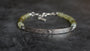 A Grossular Garnet beaded Bracelet with faceted Garnets ranging in colur fro soft grass green to olive and brown tones. Sterling Silver Celtic Bar with a main done surrounded by engraved scroll work. 