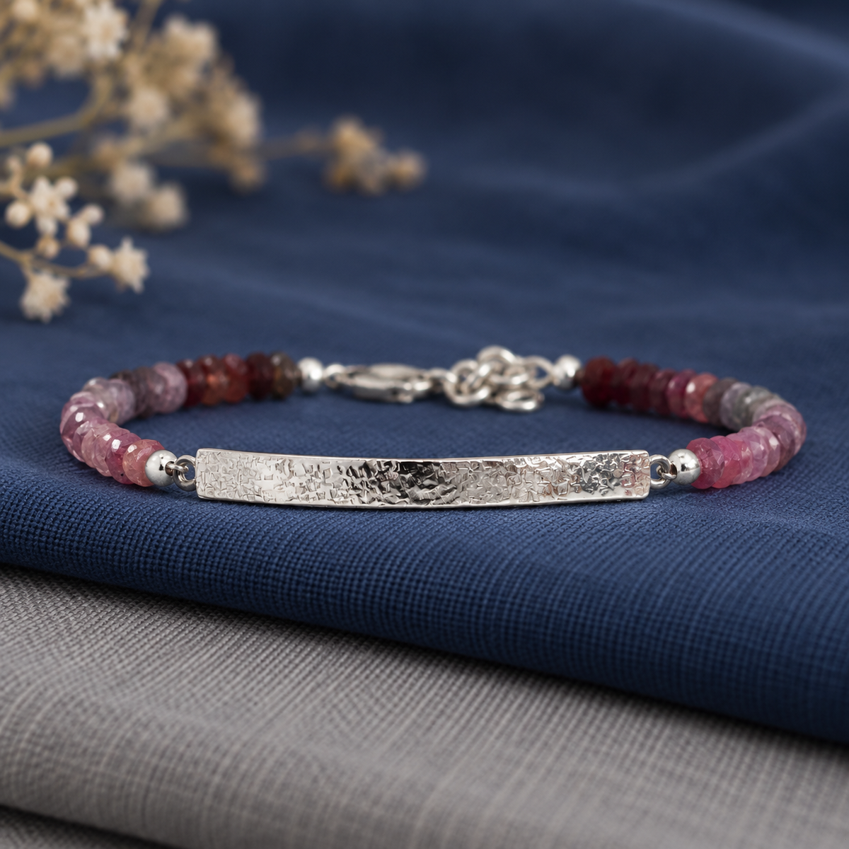 Artisan rainbow spinel gemstone bracelet featuring a gently curved textured silver bar and faceted natural gemstones