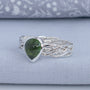 Side view of olive green tourmaline ring with woven Argentium silver band