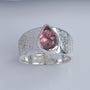 Close-up of pink tourmaline set on a dusted textured silver ring band